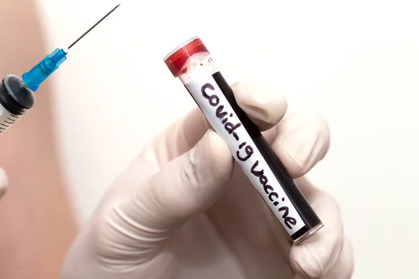 Vacina Covid-19 no tubo sanguíneo, médico usando luvas médicas segurando um tubo sanguíneo com Coronavirus positivo 2019-nCoV Amostra de Sangue com injeção . — Fotografia de Stock