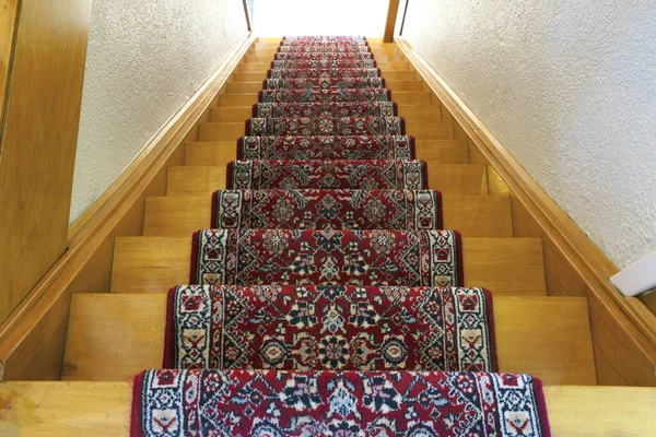 Escaliers avec bande de tapis à motif rouge, vieil escalier en bois vintage, design antique — Photo