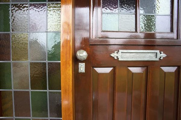 Вхідні двері з вітражем і металевою дверною ручкою, старовинний дизайн крупним планом — стокове фото