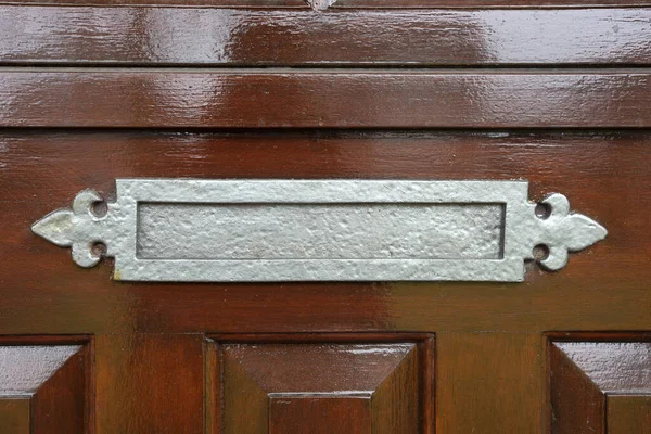 Λαμπερό μεταλλικό κουτί σε μια καφέ ντεμοντέ ξύλινη πόρτα, κλασικό σχεδιασμό close-up — Φωτογραφία Αρχείου