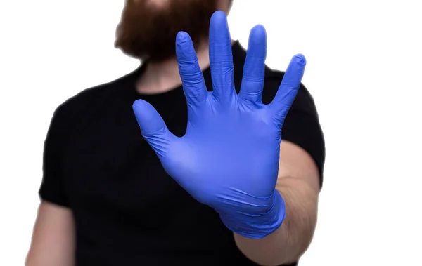 Mans hand in blue medical gloves with the words Stay Home, self isolation or quarantine covid-19 coronavirus — Stock Photo, Image