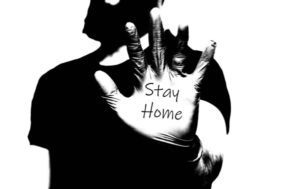 Les hommes portent des gants médicaux bleus avec les mots Stay Home, self isolation ou quarantaine covid-19 coronavirus noir et blanc — Photo