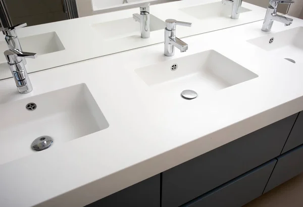 Kolme pesuallas kylpyhuone kolme pesuallas ja kolme hana valkoinen moderni muotoilu peili — kuvapankkivalokuva