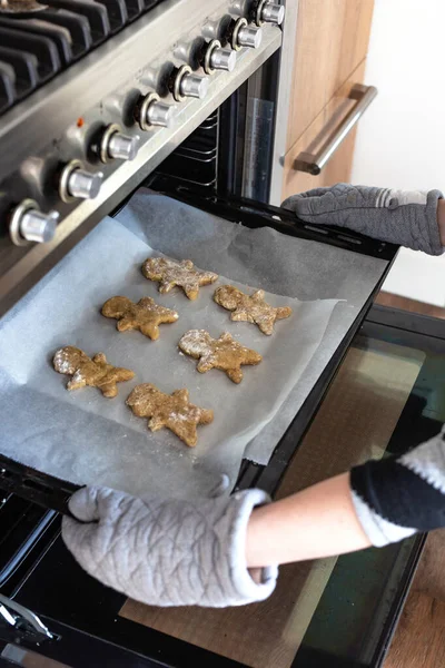 Assar o homem de gengibre no forno, mulher fazendo biscoitos caseiros do homem de gengibre no forno — Fotografia de Stock