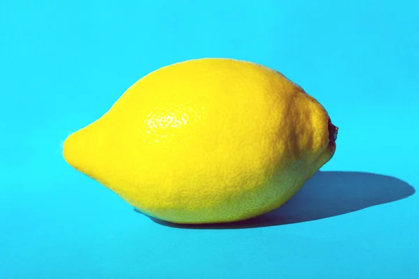 Jeden świeży żółty cytryna na niebieskim tle, lato zdrowej żywności pojęcie kolorowe — Zdjęcie stockowe
