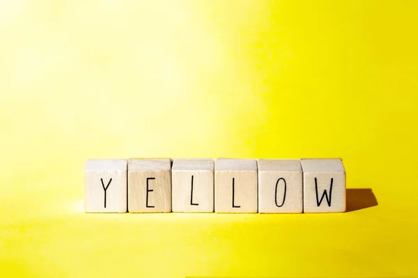 노란색 배경에 노란색이라는 단어가 붙어 있는 우묵 한 큐브, 유쾌 한 여름 컨셉의 화려 한 역 디자인 — 스톡 사진