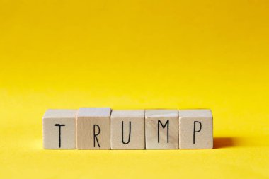 Turuncu arka planda Trump yazan tahta küpler, Başkan Amerika konsepti.