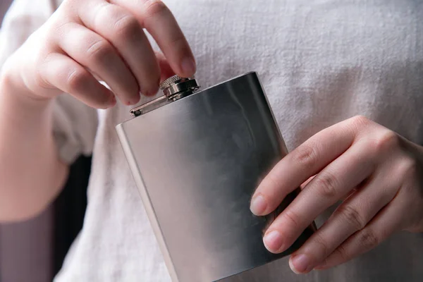 Hand met een roestvrijstalen heupfles voor een close-up van drank, alcohol en drank — Stockfoto