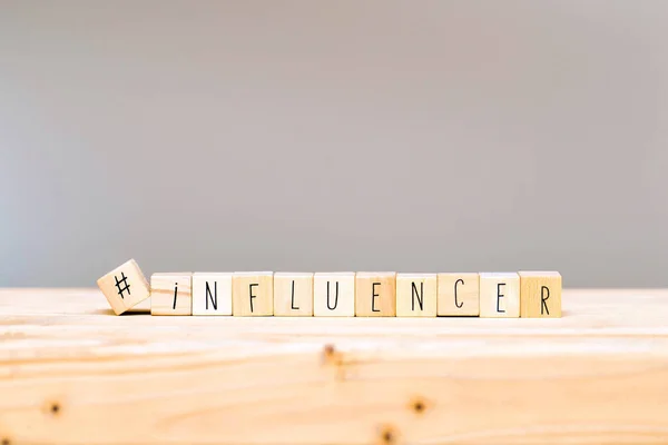 Cubos de madera con un hashtag y la palabra Influencer, concepto de redes sociales y fondo — Foto de Stock