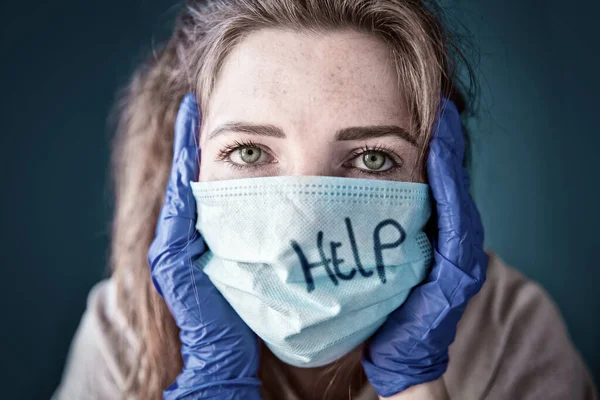 Mujer joven con guantes protectores y mascarilla dentro de una casa en cuarentena que parece aburrida y triste, para Covid-19 Coronavirus, con fondo azul —  Fotos de Stock