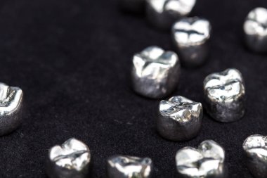Diş gümüş metal diş kron koyu siyah yüzeyi.