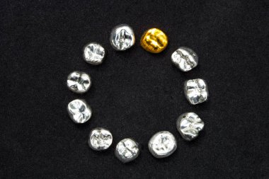 Diş kron koyu siyah yüzeyinde diş altın ve metal.