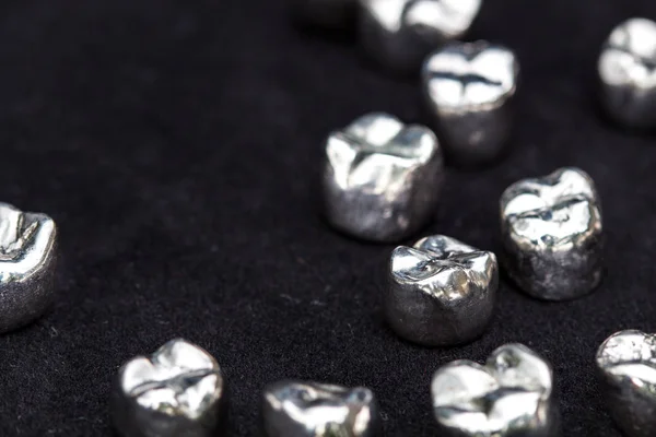 Diş gümüş metal diş kron koyu siyah yüzeyi.