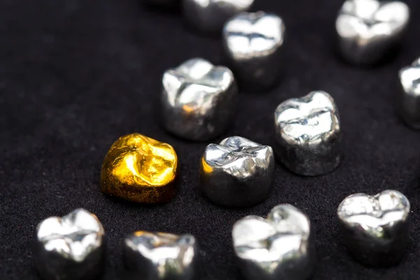 Diş kron koyu siyah yüzeyinde diş altın ve metal.