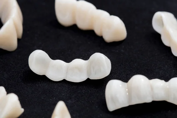 Puentes dentales de cerámica o zirconio sobre superficie negra oscura . —  Fotos de Stock