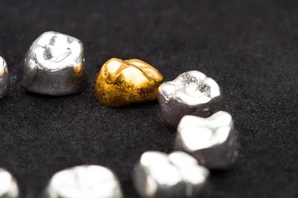 Diş kron koyu siyah yüzeyinde diş altın ve metal.