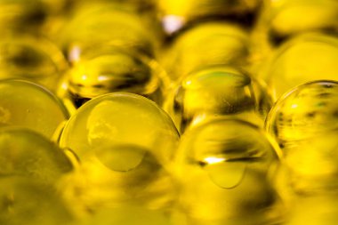 Altın parlak su jel topları. Makro fotoğraf, reklam veya kozmetik, takı ve tıp için kullanılabilir. Arka plan.