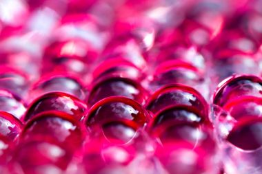 Kırmızı parlak su jel topları. Makro fotoğraf, reklam veya kozmetik, takı ve tıp için kullanılabilir. Arka plan.