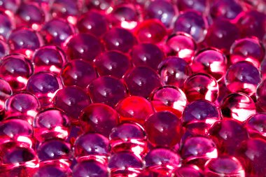 Kırmızı parlak su jel topları. Makro fotoğraf, reklam veya kozmetik, takı ve tıp için kullanılabilir. Arka plan.