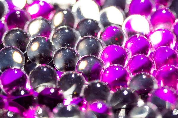 Mor ve koyu su jel topları. Makro fotoğraf, reklam veya kozmetik ve ilaç için kullanılabilir. Arka plan.