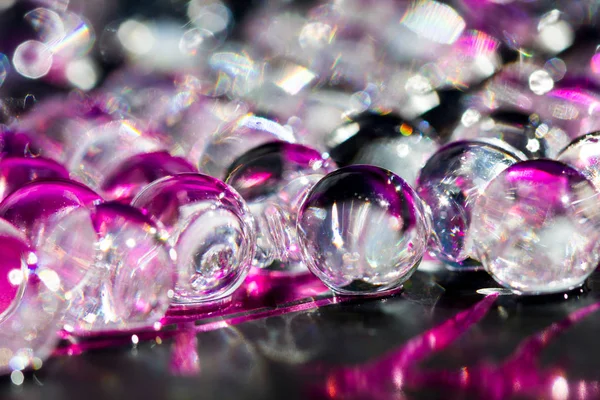 Mor ve koyu su jel topları. Makro fotoğraf, reklam veya kozmetik ve ilaç için kullanılabilir. Arka plan.
