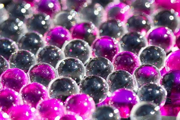 Mor ve koyu su jel topları. Makro fotoğraf, reklam veya kozmetik ve ilaç için kullanılabilir. Arka plan.