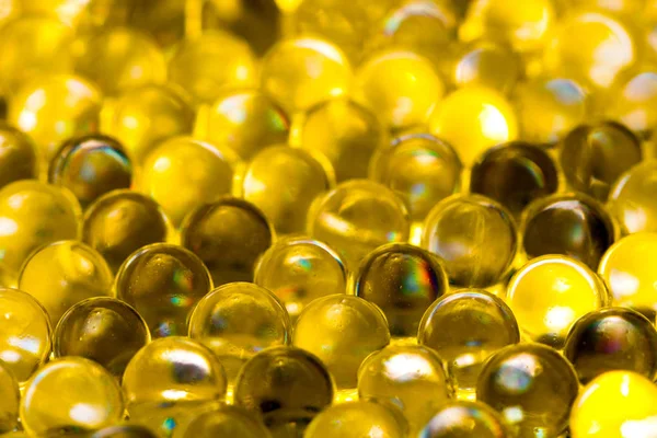 Gouden glanzend water gel ballen. Macro foto, kan worden gebruikt zowel voor reclame of cosmetica, juwelen geneeskunde. Abstracte achtergrond. — Stockfoto