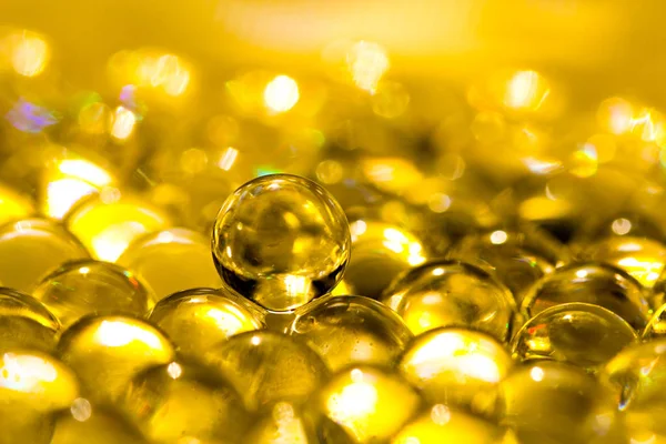 Altın parlak su jel topları. Makro fotoğraf, reklam veya kozmetik, takı ve tıp için kullanılabilir. Arka plan.
