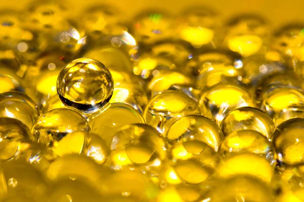 Gouden glanzend water gel ballen. Macro foto, kan worden gebruikt zowel voor reclame of cosmetica, juwelen geneeskunde. Abstracte achtergrond. — Stockfoto