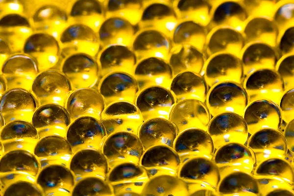 Gouden glanzend water gel ballen. Macro foto, kan worden gebruikt zowel voor reclame of cosmetica, juwelen geneeskunde. Abstracte achtergrond. — Stockfoto