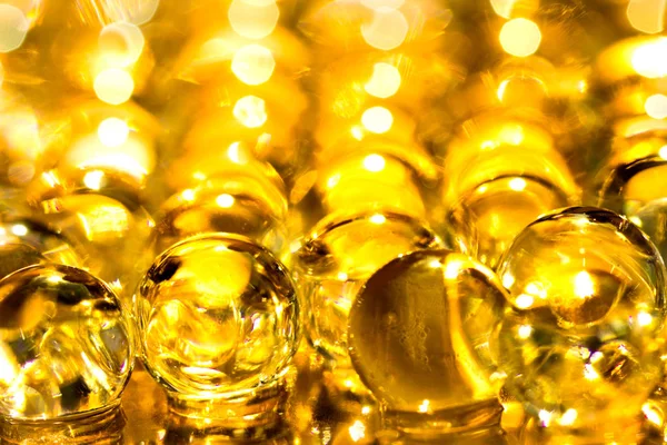 Altın parlak su jel topları. Makro fotoğraf, reklam veya kozmetik, takı ve tıp için kullanılabilir. Arka plan.