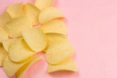 Patates cipsi minimalizm tarzı pastel pembe arka plan üzerinde.