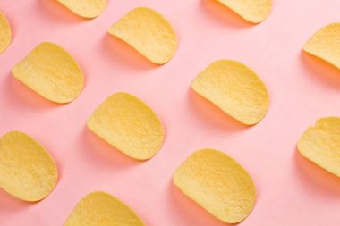 Patates cipsi minimalizm tarzı pastel pembe arka plan üzerinde.