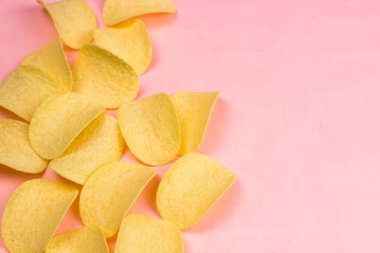 Patates cipsi minimalizm tarzı pastel pembe arka plan üzerinde.