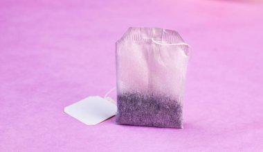 Pastel pembe arka plan minimalizm tarzı üzerinde çay poşeti.