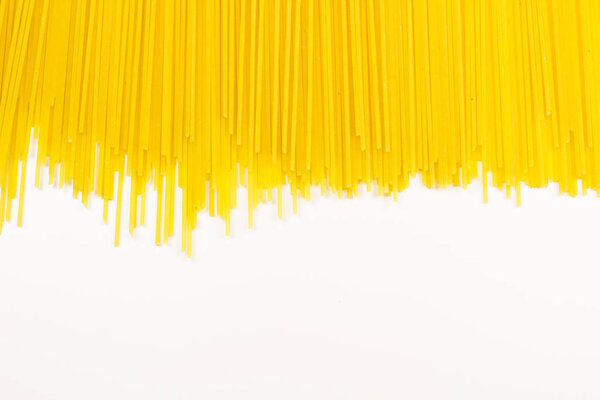 Длинная желтая паста выделена на белом фоне крупным планом
.