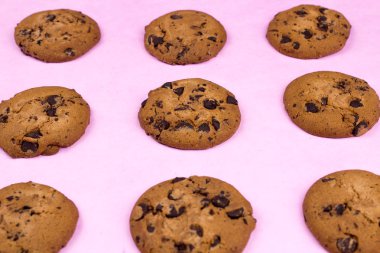 Chokolate pastel pembe bir arka plan üzerinde tatlı kurabiye.