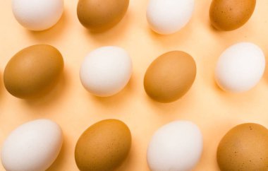 Pastel arka plan üzerinde beyaz ve sarı Paskalya yumurtaları makroyu kapatın.