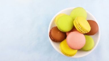 Tatlı renk macaroons veya macaron beyaz tabak içinde döndürün. Üstten Görünüm.