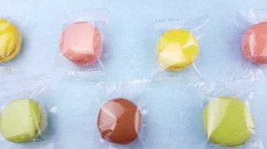 Tatlı renk macaroons veya macaron şeffaf paket pastel mavi arka plan üzerinde. Yakın çekim.