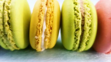 Tatlı renk macaroons veya macaron pastel pembe bir arka plan üzerinde. Slayt kadar kapatın.