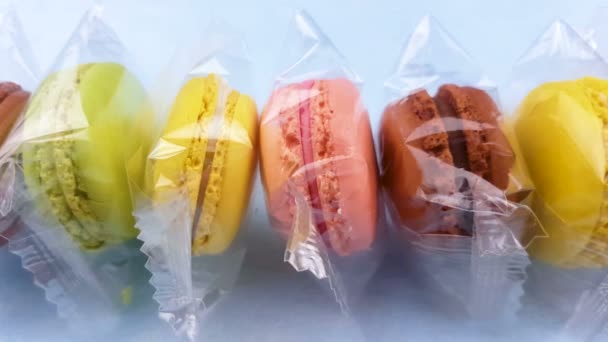 Zoete Kleur Bitterkoekjes Macaron Transparante Pakket Pastel Blauwe Achtergrond Close — Stockvideo
