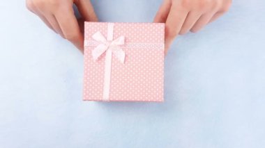 Kadın el macaroons veya pastel mavi zemin üzerine içinde macaron pembe kutusunu aç.
