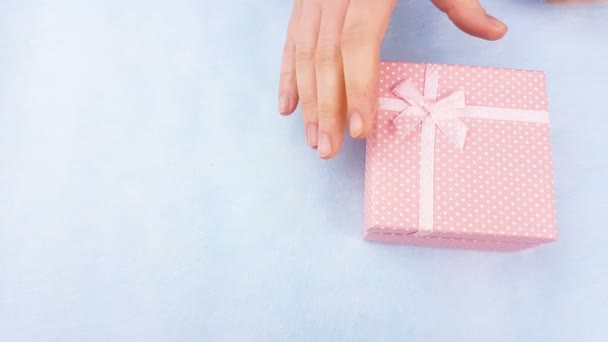 妇女手打开粉红色盒与杏仁或 Macaron 内的粉彩蓝色背景 — 图库视频影像