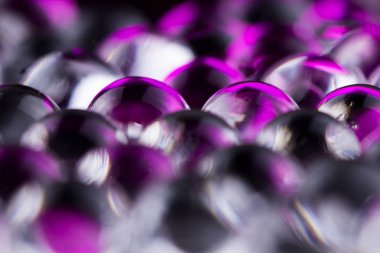 Mor ve koyu su jel topları. Makro fotoğraf, reklam veya kozmetik ve ilaç için kullanılabilir. Arka plan.