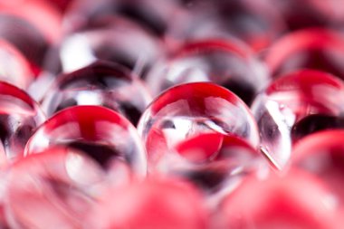 Kırmızı parlak su jel topları. Makro fotoğraf, reklam veya kozmetik, takı ve tıp için kullanılabilir. Arka plan.