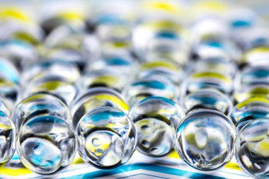 Mavi ve sarı su jel topları. Makro fotoğraf, reklam veya kozmetik ve ilaç için kullanılabilir. Arka plan.