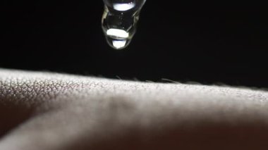 Pipetten kadın elinin derisine düşen küçük bir serum jeli sıvısı. Derinin üzerine düşen makro sağlık kozmetik serumu..
