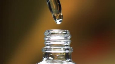 Pipet makrosunu cam şişeye serum sıvısı damlatarak kapat. Kozmetik sağlık hizmetleri veya cilt rengi sıvısının 4k yavaş çekim görüntüsü.
