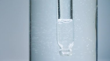 İçinde pipet ve jel içinde hava kabarcıkları olan sağlık hizmeti serumu şişesini kapatın. Makro atış. 4k kozmetik arkaplan.